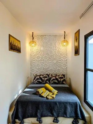 a bedroom with a bed with two yellow towels on it at Riad LISA 6 personnes in Marrakech