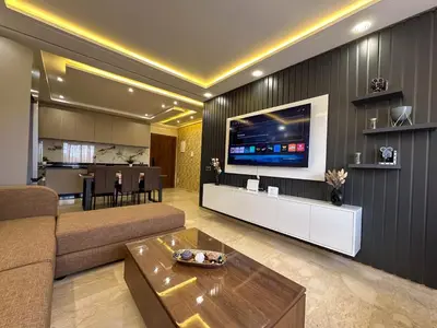 a living room with a couch and a tv on a wall at Appartement neuf 1 Ch - 5 min de la gare in Marrakech