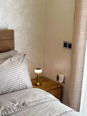 a bedroom with a bed and a lamp on a night stand at Appartement neuf 1 Ch - 5 min de la gare in Marrakech