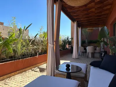 a patio with a table and chairs on a balcony at Roof top terrasse Centre-Gueliz JACUZZI in Marrakech