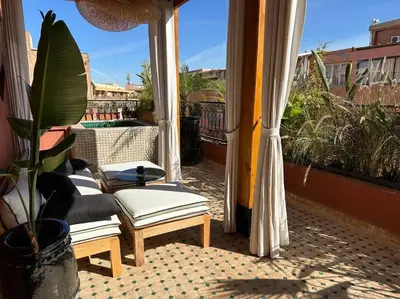 a balcony with a table and chairs and a plant at Roof top terrasse Centre-Gueliz JACUZZI in Marrakech