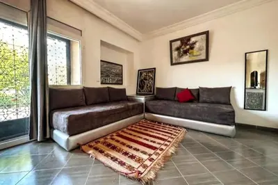 a living room with a couch and a rug at DAR SMAWAR top piscine chauffée 15mn centre ville in El Caïd Omar