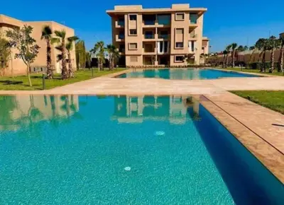 a large swimming pool in front of a building at Magnifique appartement coralia in Marrakech