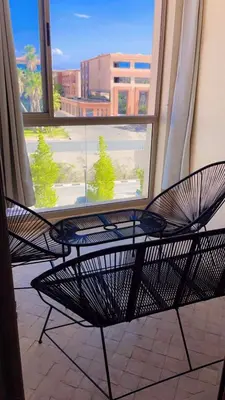 two chairs sitting in front of a window at Magnifique appartement coralia in Marrakech