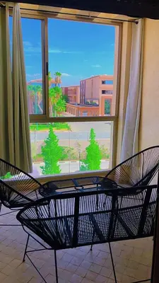 a bench in front of a window with a view at Magnifique appartement coralia in Marrakech