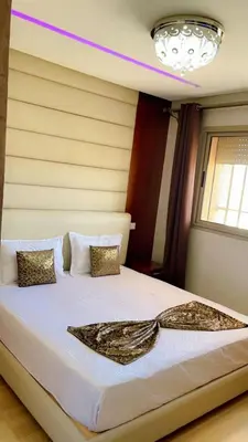 a bedroom with a large bed with white sheets and pillows at Magnifique appartement coralia in Marrakech