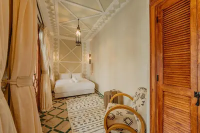 a hallway with a room with a bed and a table at Riad Senja in Marrakech