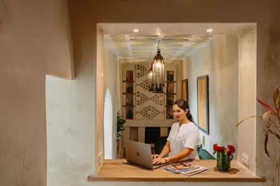 a woman sitting at a desk with a laptop at Riad Senja in Marrakech