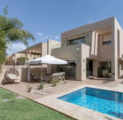 a villa with a swimming pool and a house at Villa Golf Marrakech in Marrakech