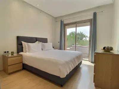 a bedroom with a large bed and a large window at Jade Prestigia Golf in Marrakech