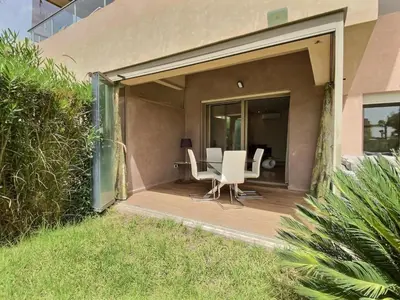 a patio with white chairs and a table on a building at Jade Prestigia Golf in Marrakech