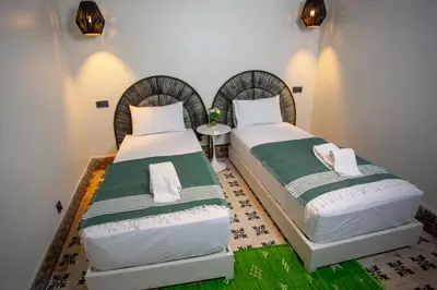 two beds sitting next to each other in a room at Riad Tawja in Marrakech