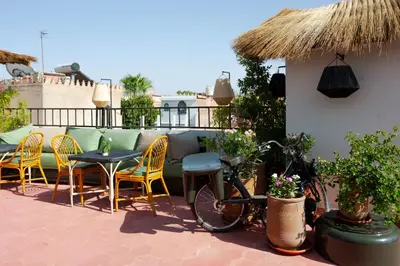 a bike parked on a patio with chairs and a table at Riad Tawja in Marrakech