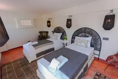 a hotel room with two beds and a table at Riad Tawja in Marrakech