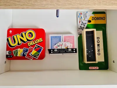 a shelf with a box of uno bluing and other toys at Dar Bouchra, Cozy Appartement, Centre Gueliz Marrakech in Marrakech