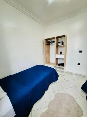 a bedroom with a blue bed in a white room at Dar Bouchra, Cozy Appartement, Centre Gueliz Marrakech in Marrakech