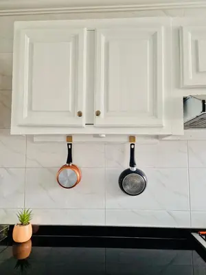 a kitchen with white cabinets and utensils on the wall at Dar Bouchra, Cozy Appartement, Centre Gueliz Marrakech in Marrakech