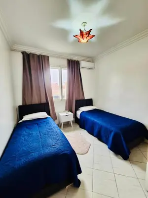 a bedroom with two beds and a window at Dar Bouchra, Cozy Appartement, Centre Gueliz Marrakech in Marrakech