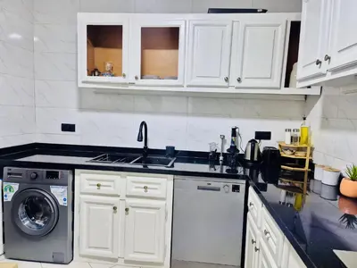 a kitchen with white cabinets and a washing machine at Dar Bouchra, Cozy Appartement, Centre Gueliz Marrakech in Marrakech