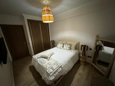 a bedroom with a bed and a pendant light at Luxury Apartment Hivernage Marrakech in Marrakech