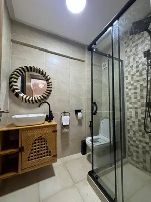 a bathroom with a shower and a sink and a mirror at Luxury Apartment Hivernage Marrakech in Marrakech