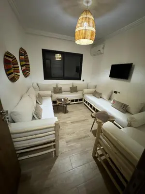 a living room with white couches and a flat screen tv at Luxury Apartment Hivernage Marrakech in Marrakech