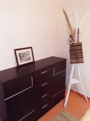 a dresser in a room with a picture and a chair at Dar Diego des appartements au Centre de la Médina in Marrakech