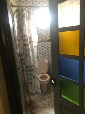 a bathroom with a toilet with a shower curtain at Dar Diego des appartements au Centre de la Médina in Marrakech