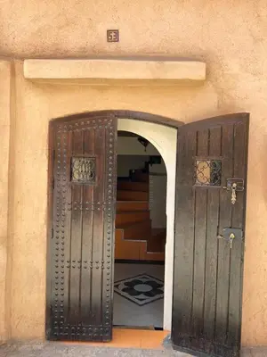 an entrance to a building with two wooden doors at Dar Diego des appartements au Centre de la Médina in Marrakech