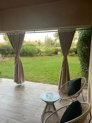 a patio with chairs and a table and a window at Prestigia marrakech in Marrakech