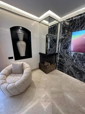 a living room with a chair and a television at Ultra-Luxury 2-Bedroom Apartment in City Center Atlas View in Marrakech