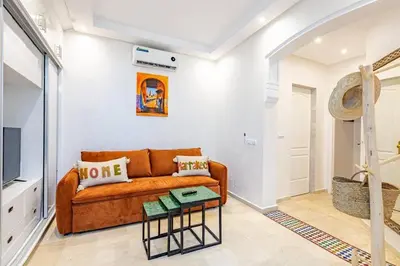 a living room with a couch and a table at Appartement avec terrasse et piscine in Marrakech