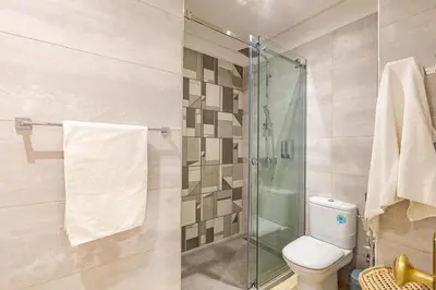 a bathroom with a toilet and a glass shower at Appartement avec terrasse et piscine in Marrakech