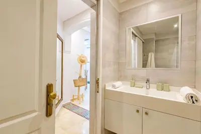 a white bathroom with a sink and a mirror at Appartement avec terrasse et piscine in Marrakech