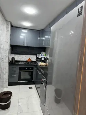 a kitchen with black cabinets and a stainless steel refrigerator at Appart à Marrakech,spacieux, calme et propre in Marrakech
