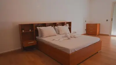 a bedroom with a large bed with a wooden headboard at Modern Apartment in Centre of Marrakech For Friends & Families in Marrakech