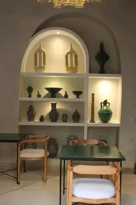 a room with a table and some vases on shelves at Riad Emberiza Sahari in Marrakech