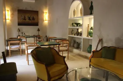 a living room with chairs and tables and a glass table at Riad Emberiza Sahari in Marrakech