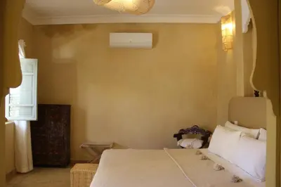 a bedroom with a bed and a window at Riad Emberiza Sahari in Marrakech