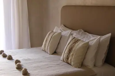 a bed with white pillows and teddy bears on it at Riad Emberiza Sahari in Marrakech
