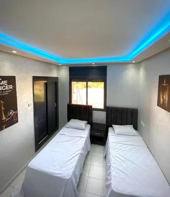 two beds in a room with blue lights at L'hivernage in Marrakech