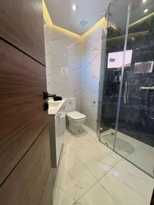 a bathroom with a toilet and a glass door at Bel Appartement Hivernage Gueliz in Marrakech