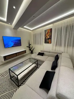a living room with a white couch and a flat screen tv at Bel Appartement Hivernage Gueliz in Marrakech