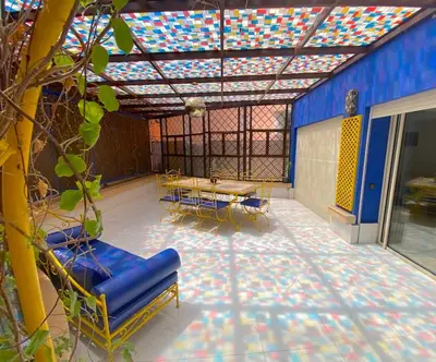 a patio with chairs and tables and a colorful ceiling at Yasmine Majorelle Marrakech in Marrakech