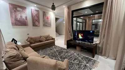 a living room with a couch and a flat screen tv at Ourika immoblier in Marrakech