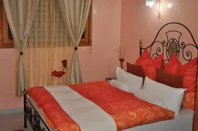 a bedroom with a large bed with red and white pillows at Zina in Marrakech