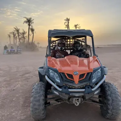 two people riding in a four wheeler in the desert at quad marrakech in Dar Caïd Layadi
