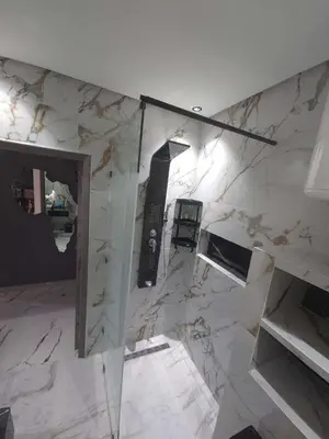 a room with a marble wall with a glass door at Apparemment chic in Marrakech