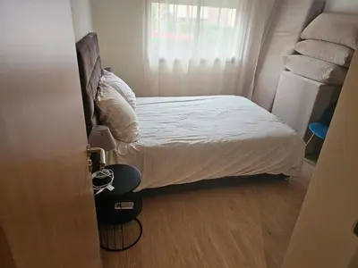 a small bedroom with a bed with white sheets at Bel appartement avec piscine et jardin in Marrakech