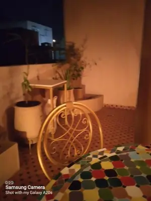 a table and a chair in a room with plants at Ykar in Marrakech